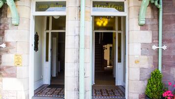 La entrada de un edificio con dos puertas que indican "Auld Man's" y "Hazeldeane".