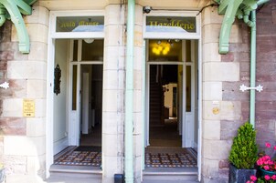 La entrada de un edificio con dos puertas que indican "Auld Man's" y "Hazeldeane".