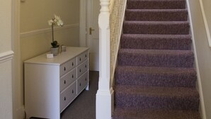 A staircase with a white railing and purple carpet leading to a door. - Hazeldene Guest House (Perth)
