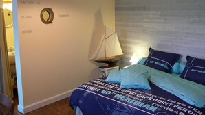 A bedroom with a bed, a sailboat decoration, and a wall with text. - B&B La Ferme de l'Ostrevent (Estrées)
