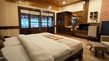 Un dormitorio con una cama grande, un escritorio, una silla y un televisor.
