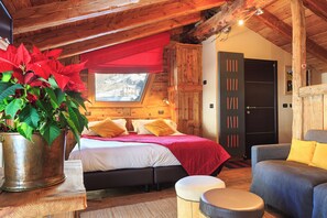 A cozy bedroom with a bed, a window, a wooden ceiling, and a door. - Locanda 4 (Valtournenche)