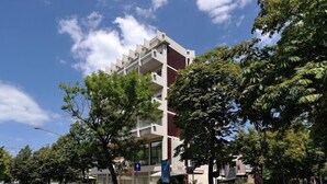 Un edificio de varios pisos con un diseño arquitectónico moderno, con balcones y ventanas grandes.