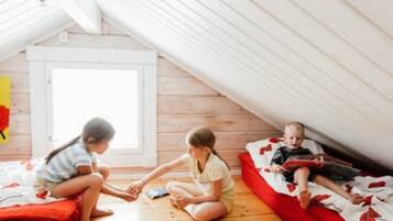 A room with a sloped ceiling, wooden flooring, and a window.