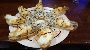 A plate of food with grilled chicken, noodles, and toast. - Posada de Bleto (Ledesma)