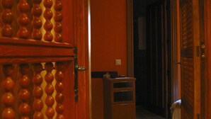 A hallway with a wooden door and a wall with a patterned design. - Posada de Bleto (Ledesma)
