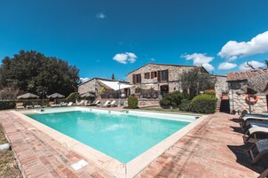 Una piscina al aire libre, sillones reclinables de piscina
