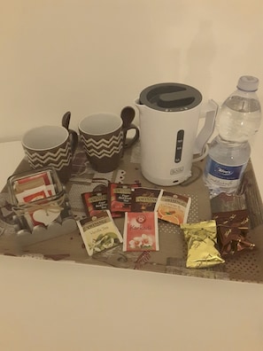 A tray with a kettle, two mugs, a water bottle, and several tea packets. - B&B Abatjour (Foggia)