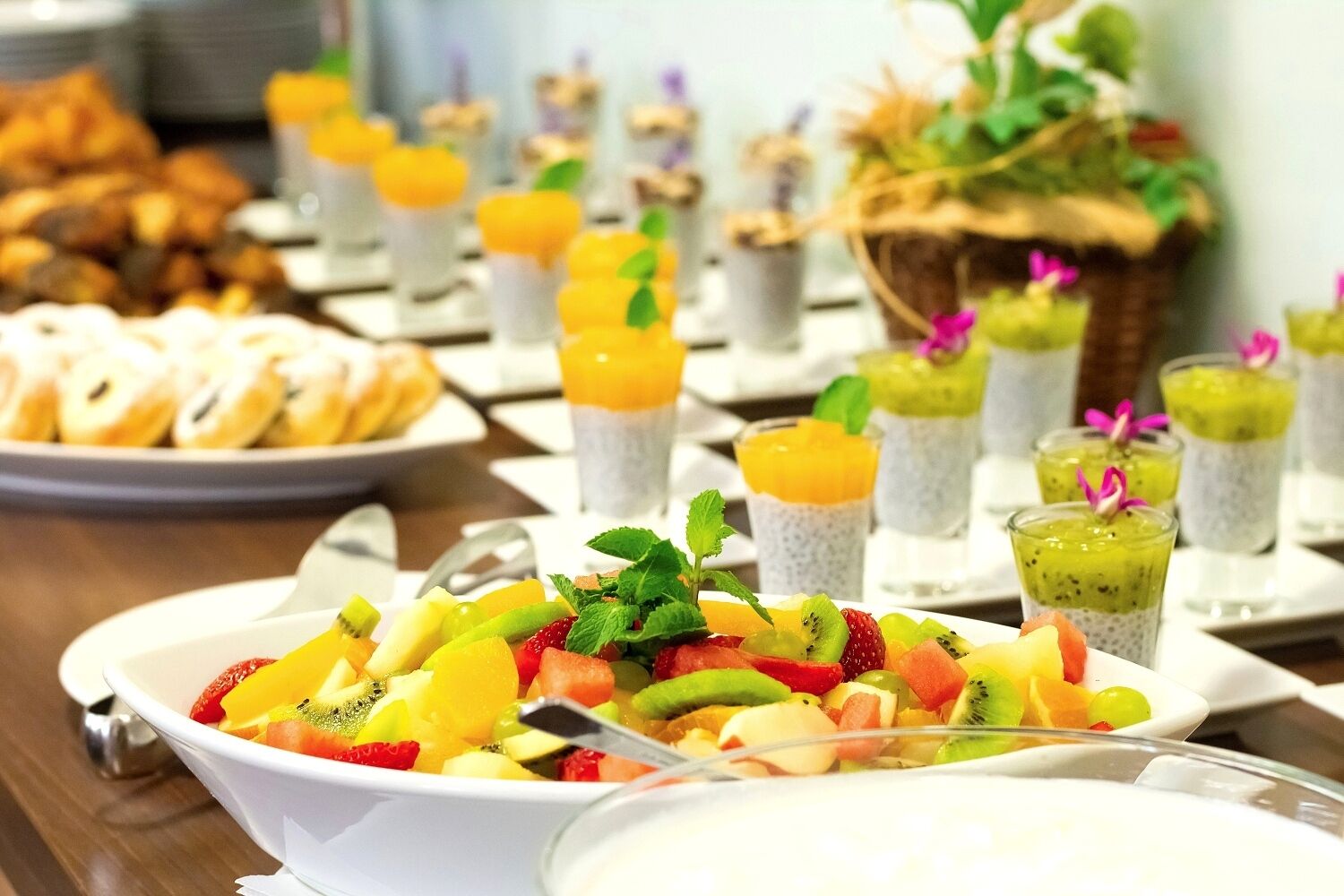 En buffé med olika rätter, inklusive fruktsallad, smoothies och bakverk.