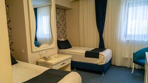 A hotel room with two beds, a desk with a telephone, and a chair. - Can Grand Hotel  (Ankara)
