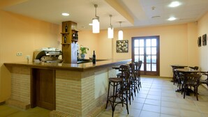 Una zona de cocina con mostrador de ladrillo, taburetes de bar y una cafetera.
