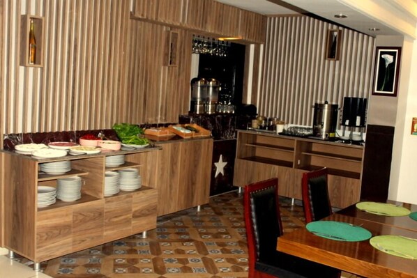 Un comedor moderno con un mostrador tipo buffet de madera, una zona de bar y un suelo estampado.
