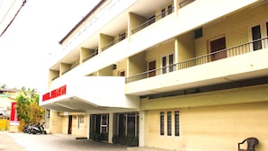 A multi-story building with a flat facade, balconies, and a sign indicating it is a hotel. - Hotel Keerthi (Thiruvananthapuram)