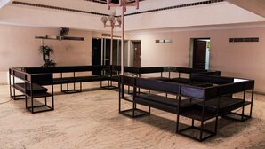 A spacious lobby with multiple seating areas, a central light fixture, and a potted plant. - Hotel Keerthi (Thiruvananthapuram)