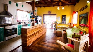 A kitchen with wooden cabinets, a stove, and a bar area. - Barrbra BnB Over The Sea (Bocas del Toro)
