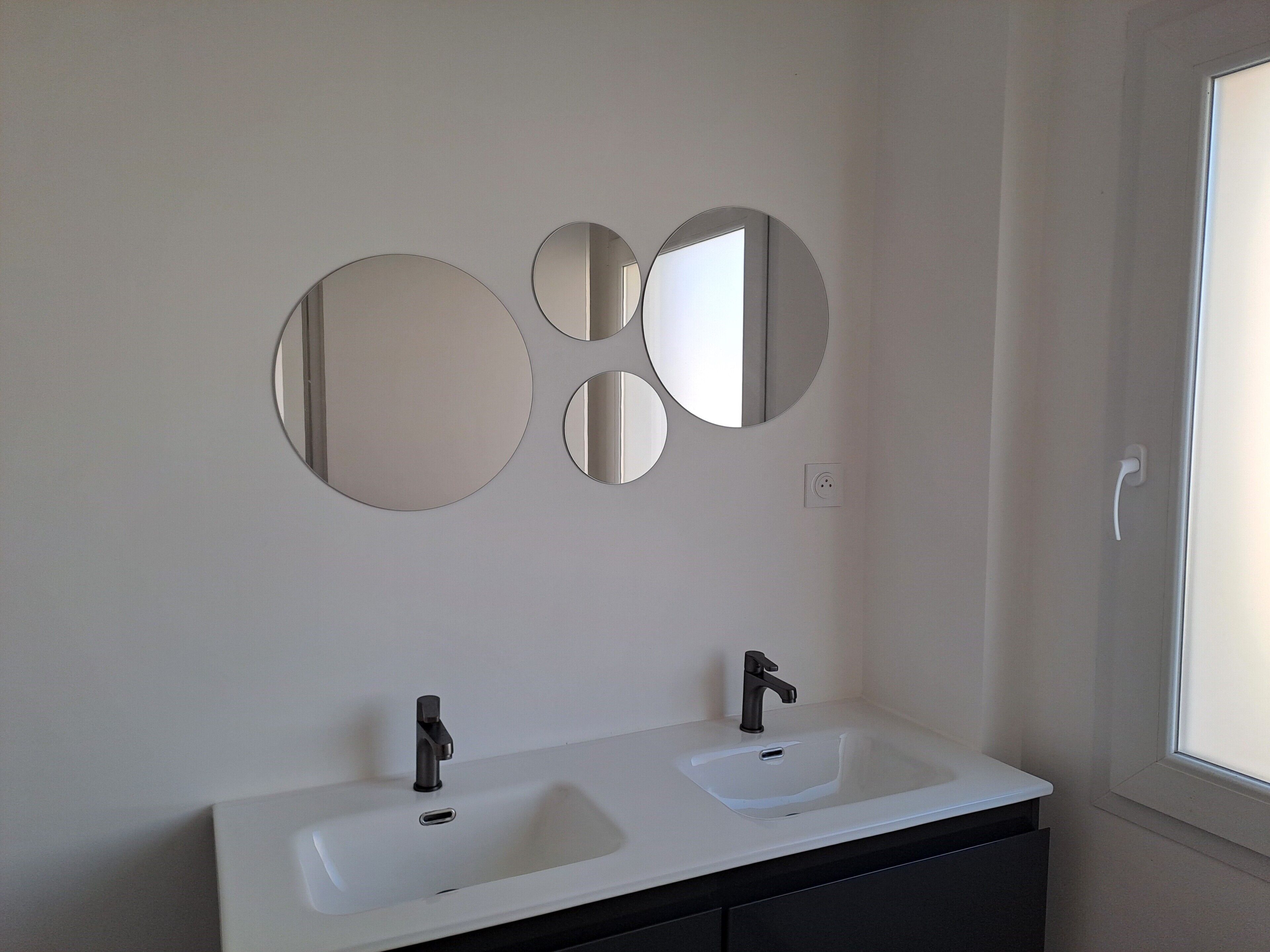 A bathroom with two sinks, a mirror, and a window.