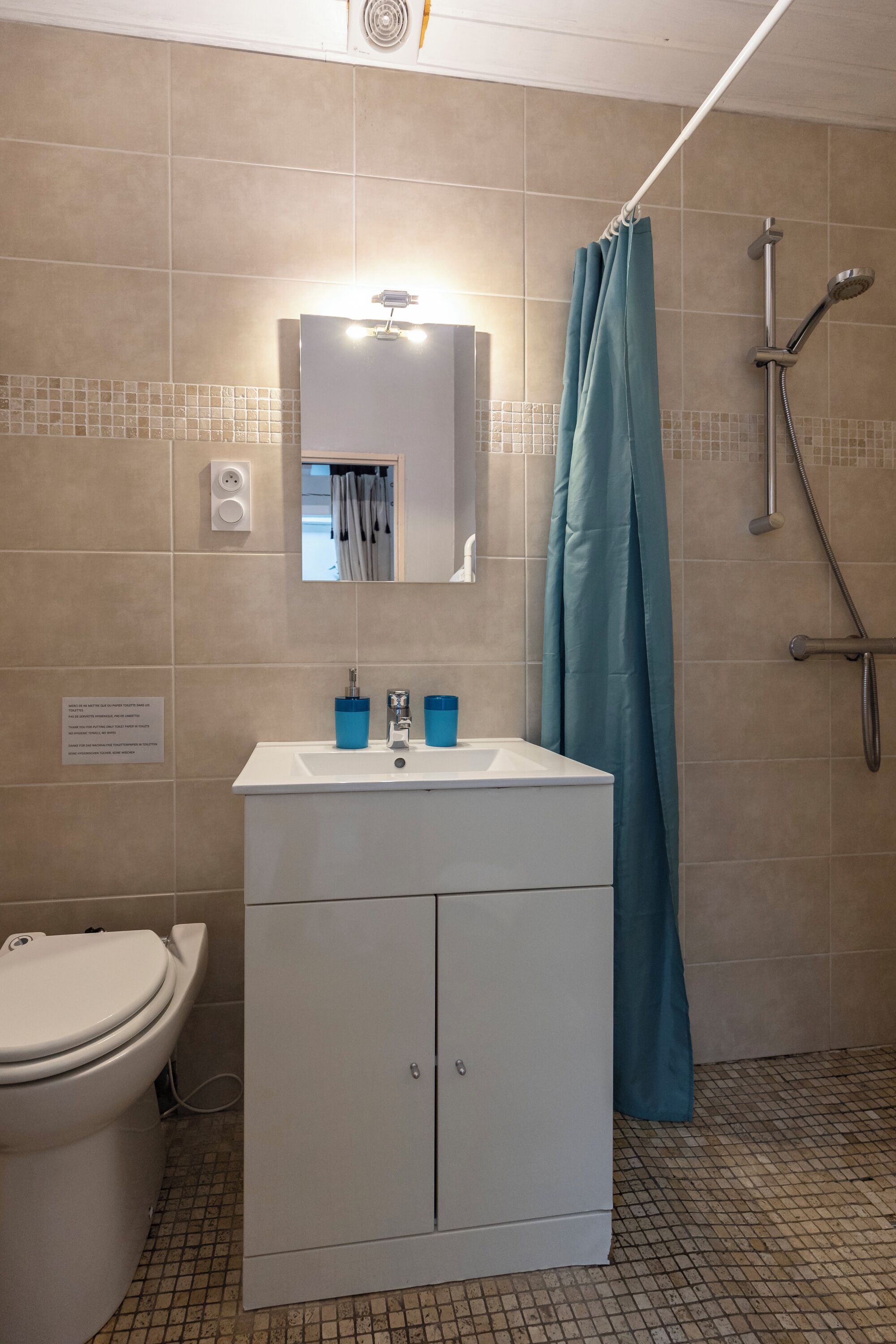 A bathroom with a white sink, mirror, and toilet.