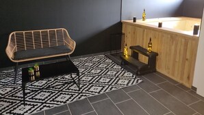 Ett modernt badrum med ett badrumsskåp i trä, en svartvit mönstrad matta och en flätad bänk.