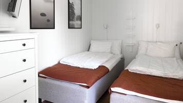 Una habitación con dos camas, un escritorio y una silla.