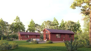 Two red wooden cabins with metal roofs, surrounded by a well-maintained lawn and trees. - Evedals Camping (Växjö)