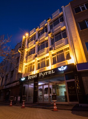 A hotel with a classic facade, multiple balconies, and illuminated signage. - iCON City Hotel (Konya)