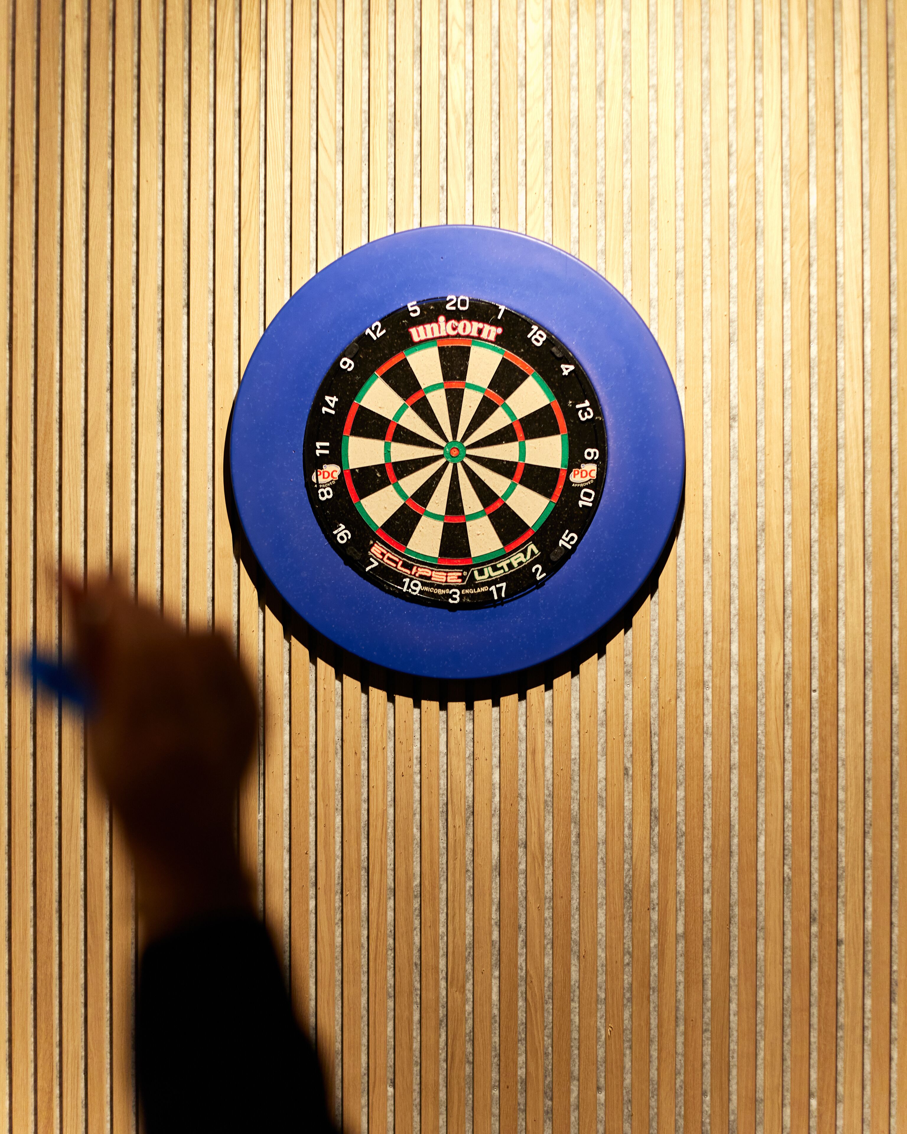 Un tablero de dardos sobre una pared de madera.
