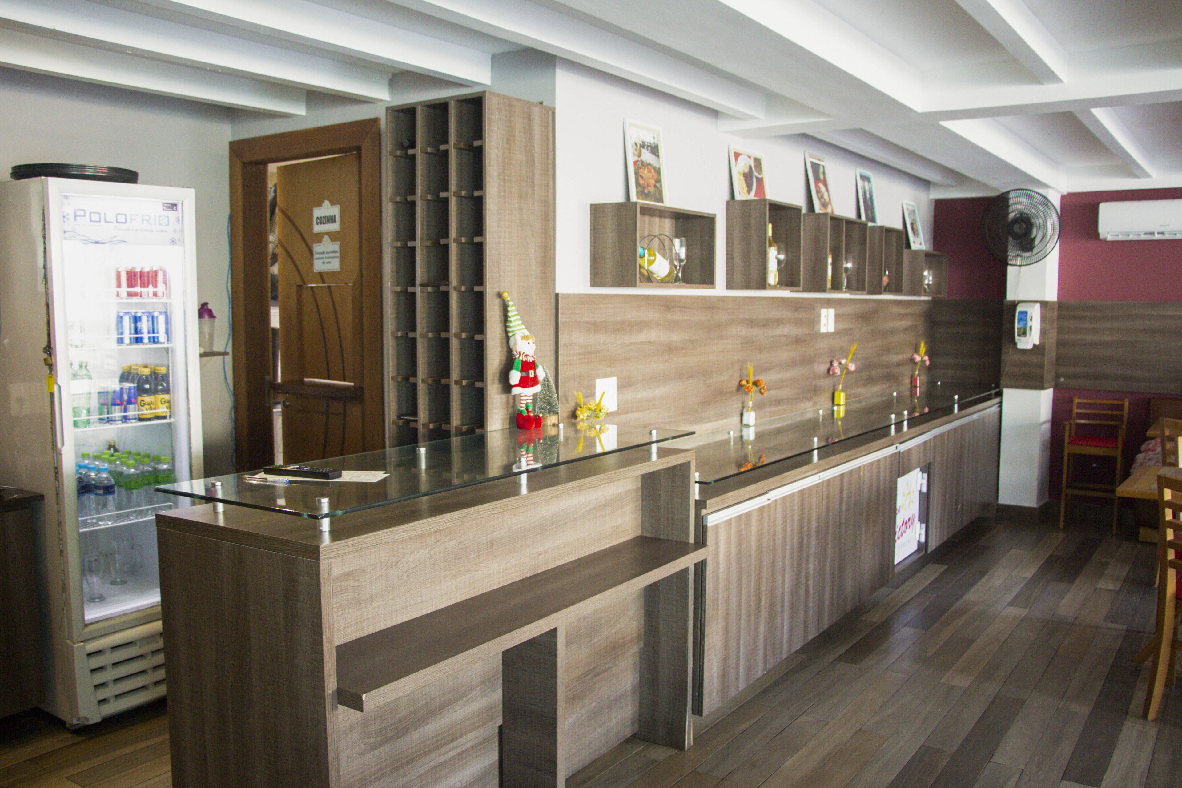 A modern kitchen with a built-in refrigerator, wooden cabinets, and a glass-top counter.