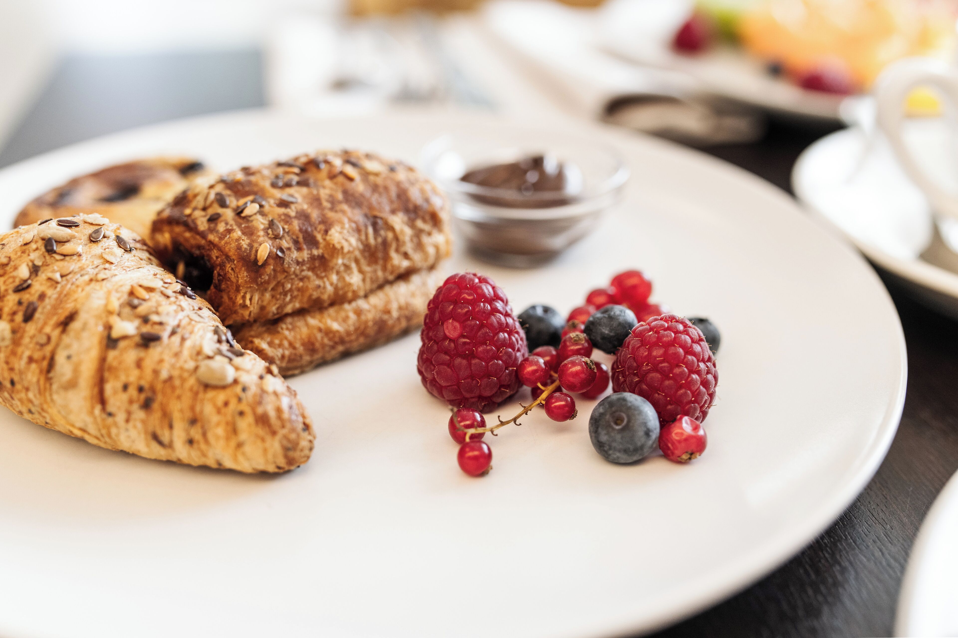 Ein Teller mit Croissants und frischen Beeren.