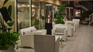 Un espacio interior moderno con mobiliario de mimbre y plantas en macetas.