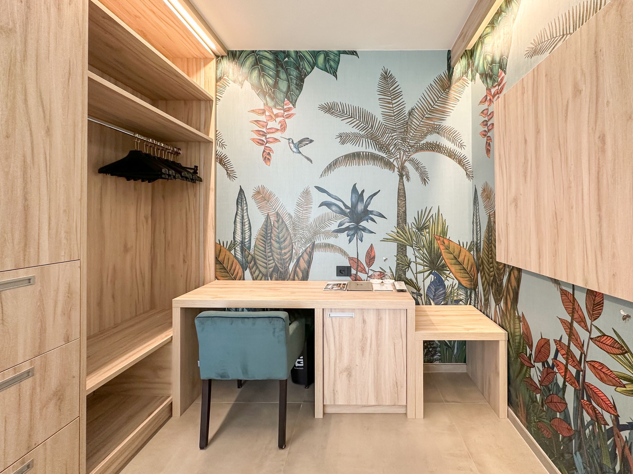 A compact room with a wooden desk, a chair, and a wardrobe.