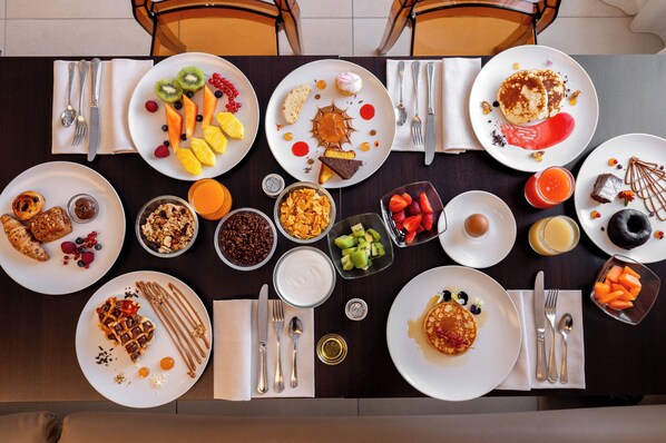 A breakfast buffet with various dishes including pancakes, fruits, and pastries. - Bellettini Hotel (Cervia)
