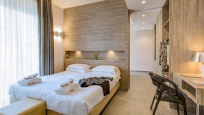 Una habitación de hotel moderna con una cama grande, un escritorio y una silla.