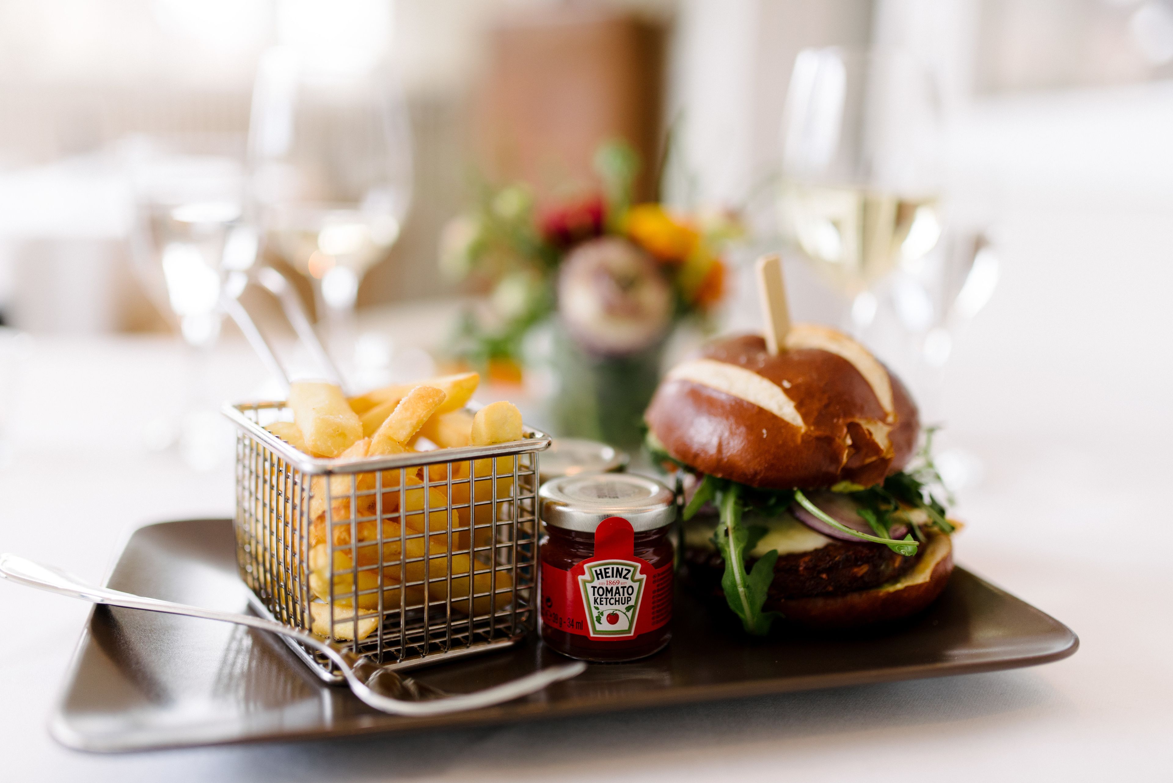 A meal consisting of a burger, fries, and ketchup on a plate.