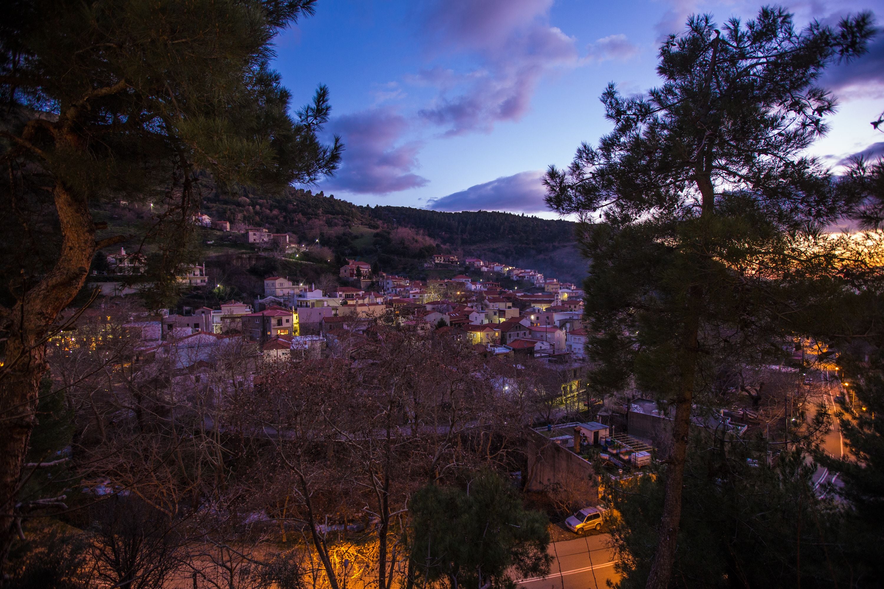 Un pueblo enclavado en un valle, con edificios rodeados de árboles.