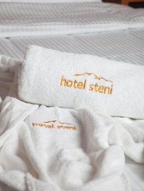 Une serviette blanche avec le mot « hôtel Steni » brodé en fil d’or.