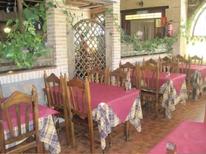 Ein Restaurant mit Holztischen und -stühlen, bedeckt mit karierten Tischdecken.