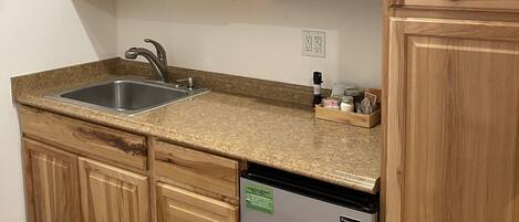 A kitchen with wooden cabinets, a stainless steel sink, a microwave, and a dishwasher.
