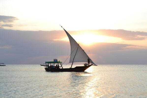 Na praia, areia branca, espreguiçadeiras, guarda-sóis 