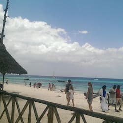 Na praia, areia branca, espreguiçadeiras, guarda-sóis