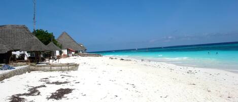 On the beach, white sand, sun-loungers, beach umbrellas