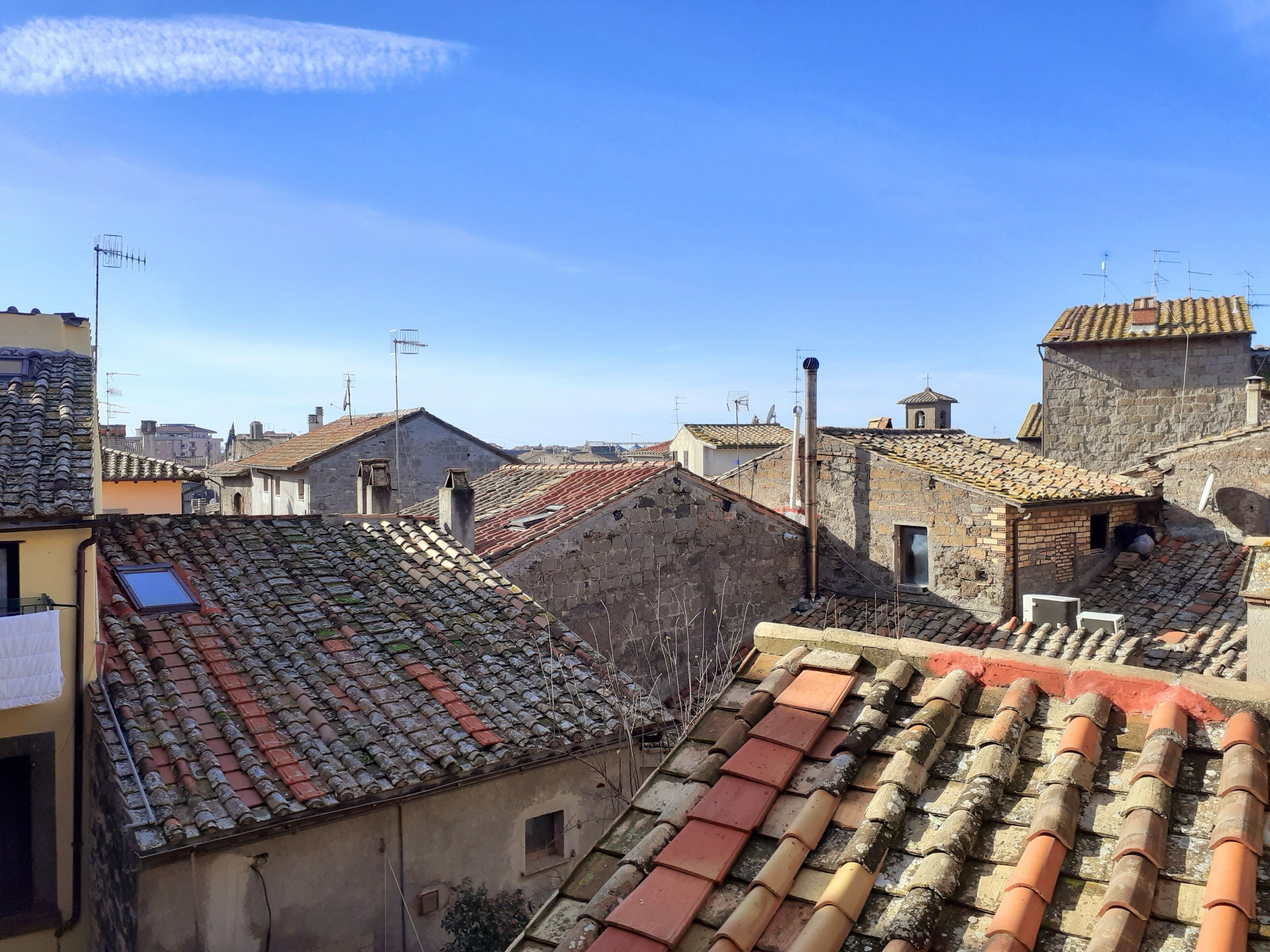 Vista de un pueblo histórico con edificios tradicionales, muros de piedra y tejados de teja.