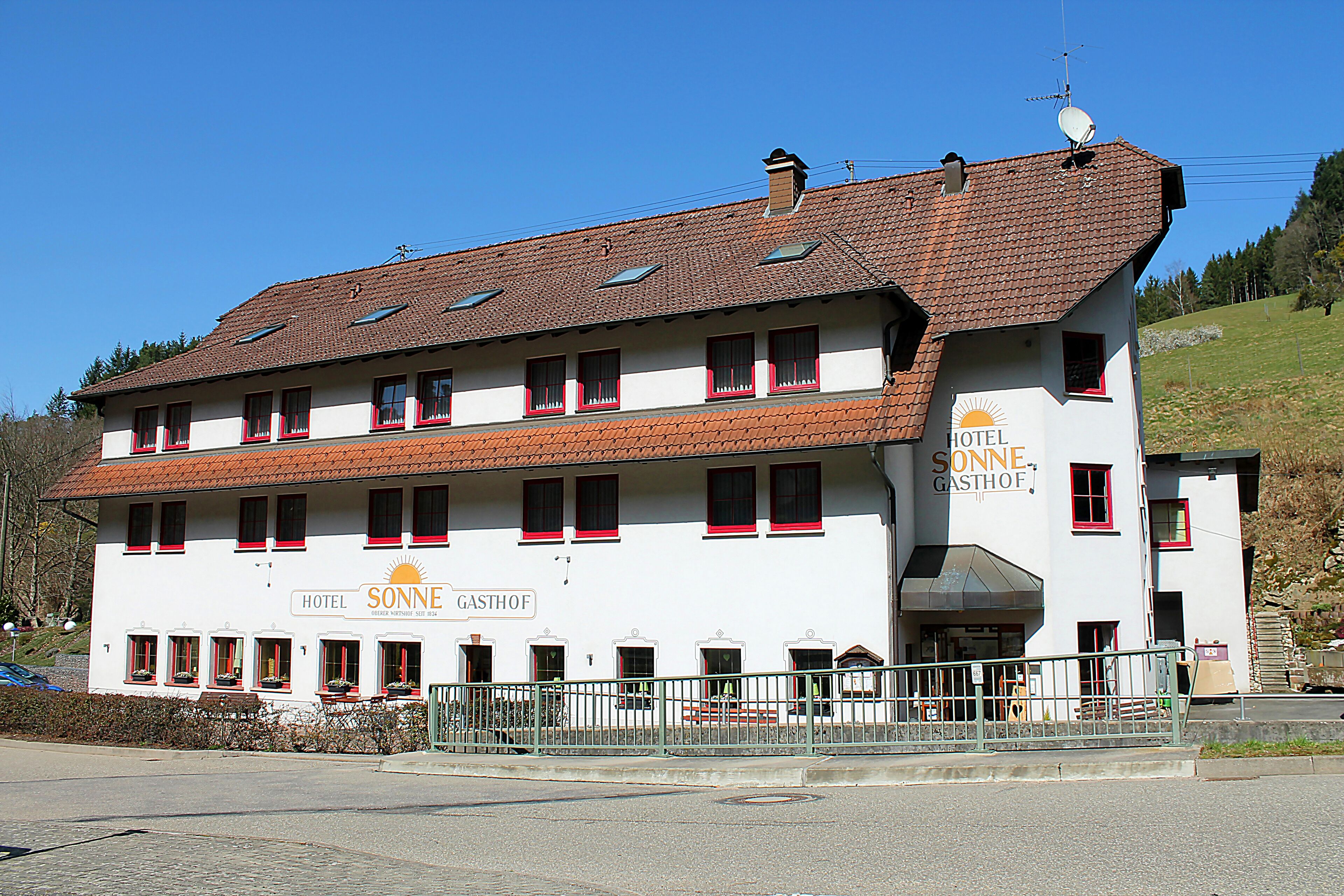 Un hotel con múltiples ventanas y un letrero que dice "HOTEL SONNE GASTHOF".
