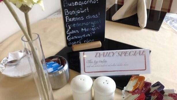 A breakfast setup with a sign reading "DAILY SPECIAL" and a flower vase. - Dunroamin (Aviemore)