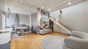 Un intérieur moderne comprenant un coin repas, un escalier et un grand miroir rond.