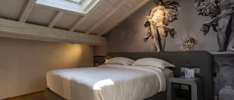 Un dormitorio moderno con un tragaluz, una cama, una mesita de noche y una estatua en la pared.