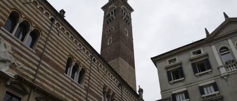 A historic building with a prominent tower featuring arched windows and a clock.