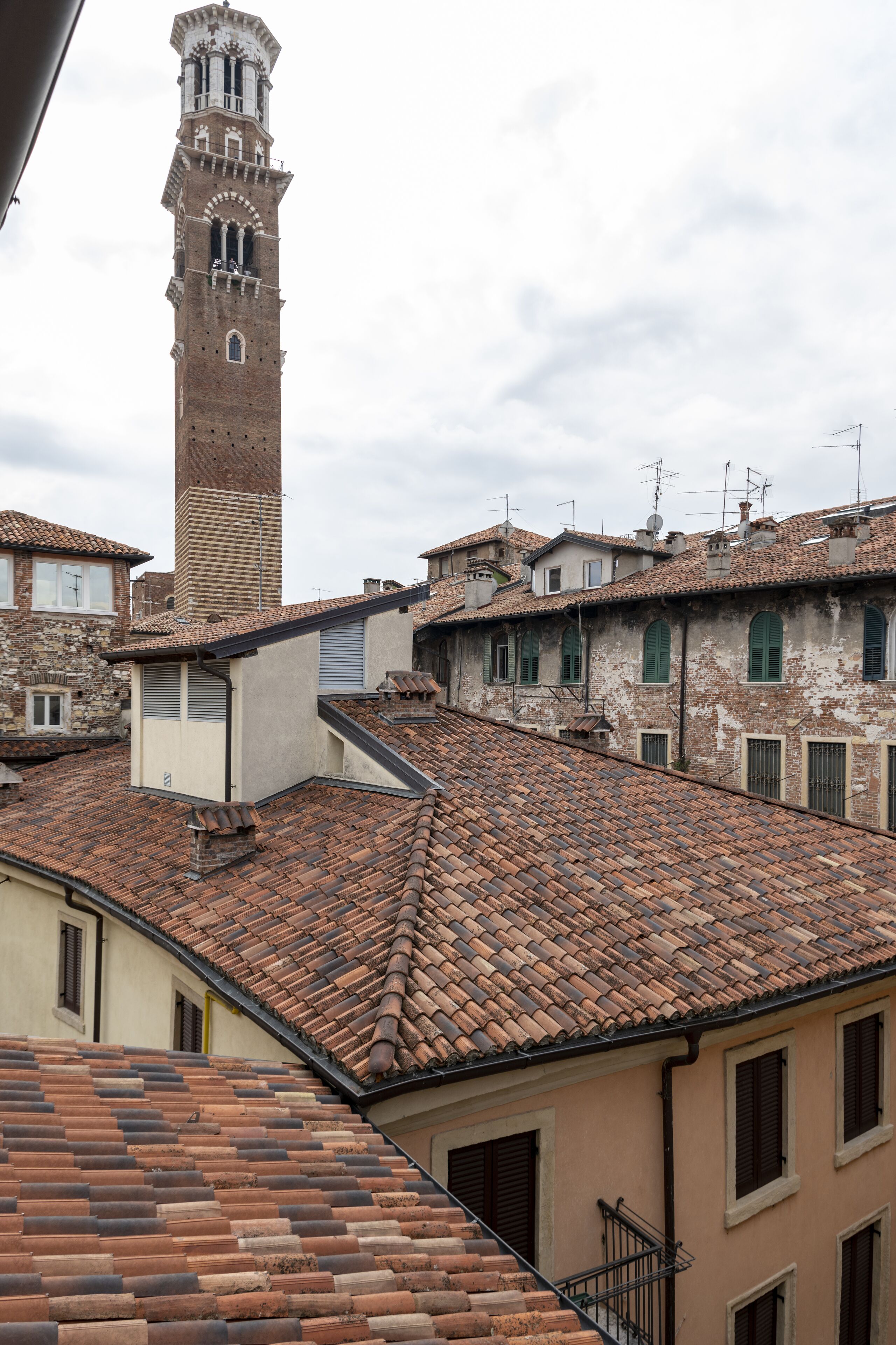 A historic building with a prominent tower, terracotta tiled roofs, and traditional architecture.