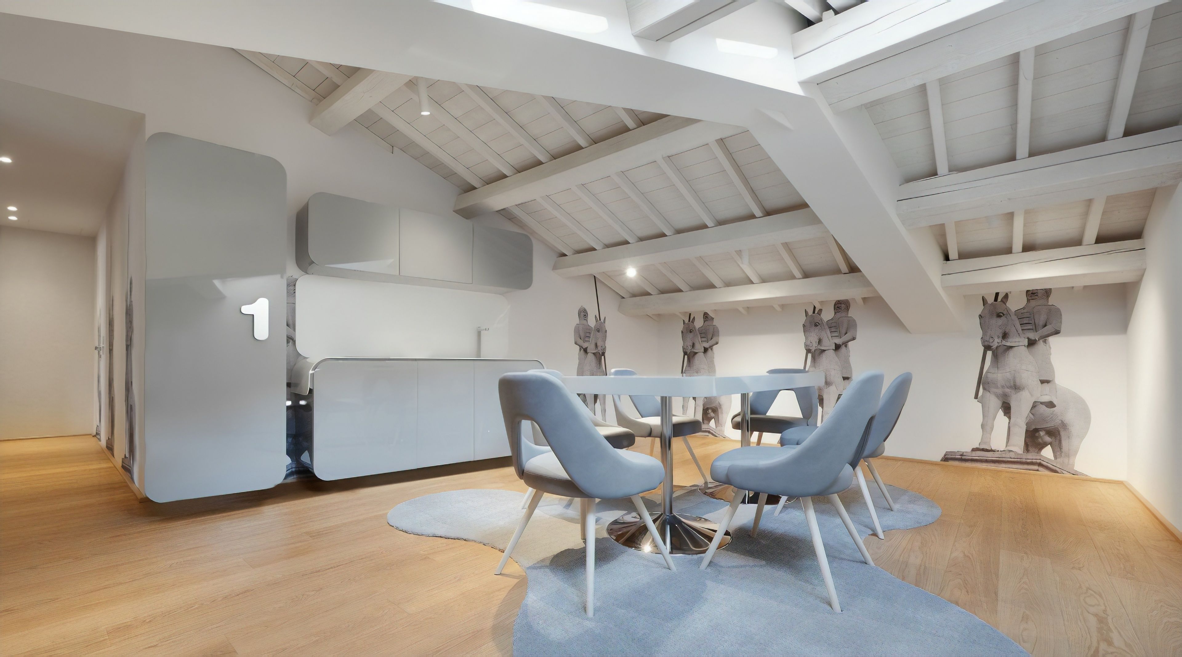 Een modern interieur met een hoge plafond, een eethoek met blauwe stoelen en een beeldhouwwerk van een ruiter en paard.
