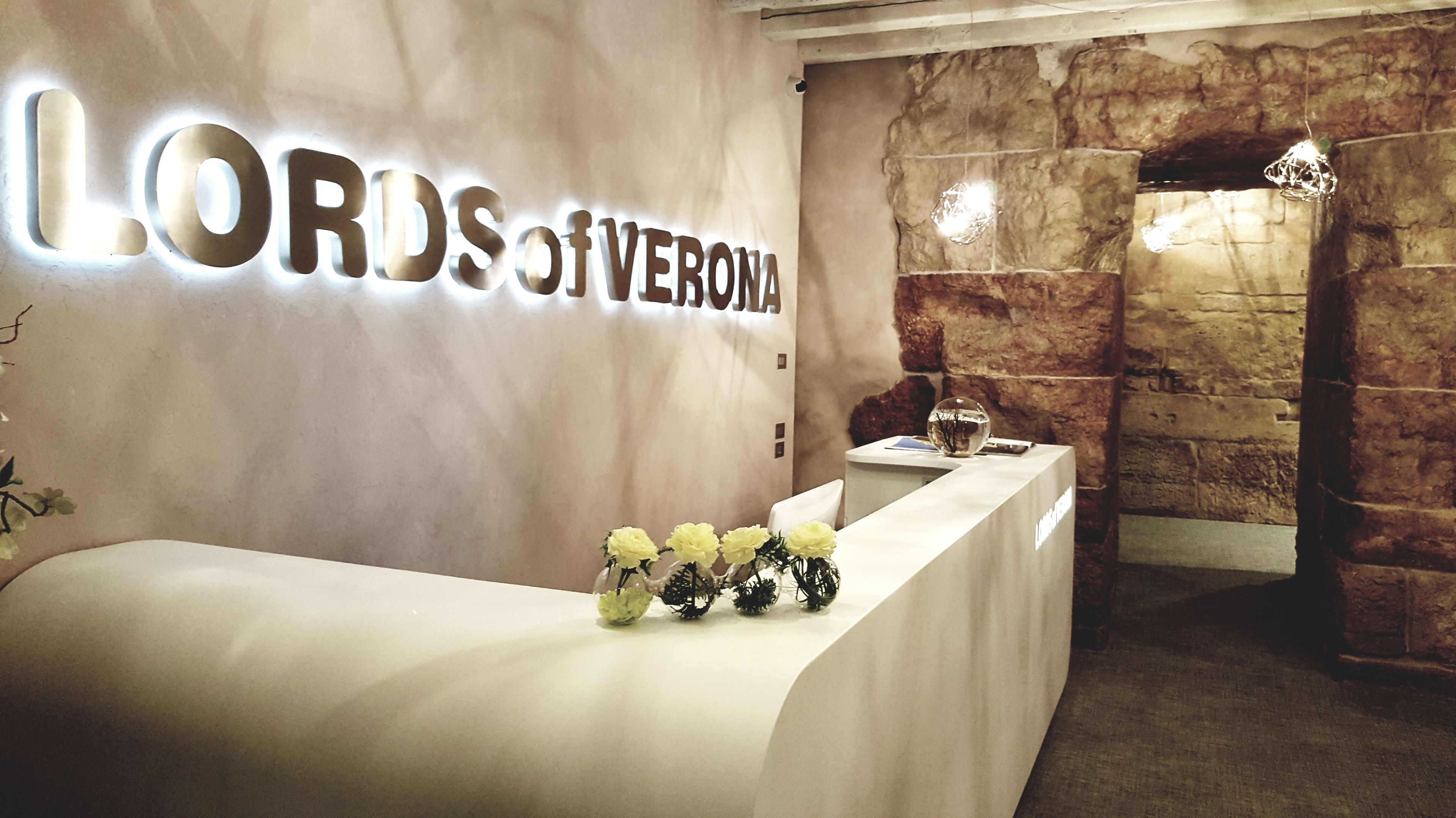 A reception area with a marble wall, a reception desk, and a stone wall backdrop.