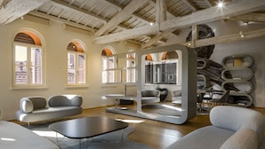 Un intérieur moderne avec un plafond haut, des fenêtres en arc de cercle et des meubles contemporains.